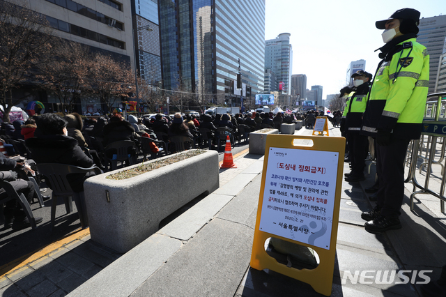 [서울=뉴시스] 조수정 기자 = 신종 코로나 바이러스 감염증(코로나 19)가 전국적으로 확산세를 보이는 가운데 23일 감염병 관리 관련 법률 등으로 집회 시위가 금지된 서울 광화문광장에서 전광훈 목사가 이끄는 문재인하야범국민투쟁본부 회원들이 집회를 하고 있다. 집회 금지 안내문 앞으로 경찰이 서 있다. 2020.02.23.  chocrystal@newsis.com