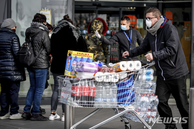 [카살푸스터렌고=AP/뉴시스' 23일 북부 이탈리아 도시의 한 슈퍼마킷 앞에서 마스크 쓴 시민들이 줄을 서 기다리고 있다. 2020. 2. 23. 