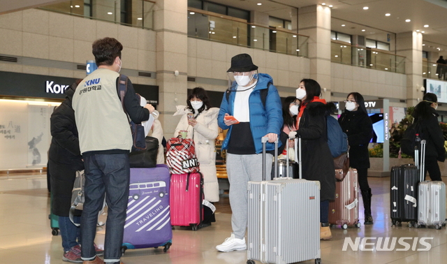 24일 강원대학교 관계자가 인천공항으로 입국하는 외국인 유학생들에게 코로나19 주의사항을 설명하고 있다.