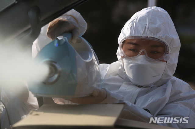 [대구=뉴시스]신종 코로나바이러스 감염증(코로나19) 확진 환자 이송을 하는 구급차 내부를 대구소방안전본부 소속 대원이 소독을 하고 있다.(사진=대구소방안전본부 제공) 2020.03.01  photo@newsis.com 