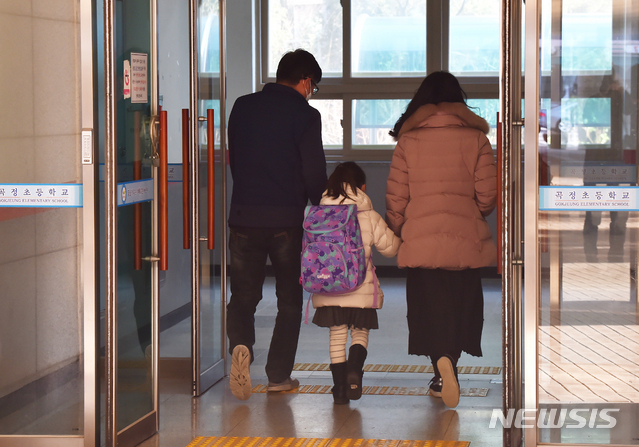 [수원=뉴시스] 김종택 기자 = 신종 코로나바이러스 감염증(코로나19) 확산에 따른 개학 연기로 긴급돌봄교실이 운영에 들어간 2일 오전 경기 수원시 한 초등학교 에서 학생들이 부모 손을 잡고 등교하고 있다. 정부는 '코로나19' 확산 우려로 개학을 연기하는 대신 긴급돌봄을 기존 일과 시간에 맞춰 오전 9시부터 오후 5시까지 운영하기로 했다. 2020.03.02. semail3778@naver.com