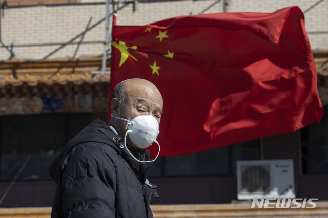 [베이징=AP/뉴시스]신종 코로나바이러스 감염증(코로나19)이 전 세계적으로 퍼진 가운데 3일 중국 베이징에서 마스크를 쓴 남성이 오성홍기 앞을 지나고 있다. 2020.03.05. 