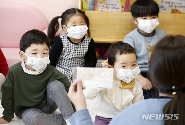[임실=뉴시스]윤난슬 기자 = 전북 임실군의 한 어린이집에서 마스크를 낀 어린이들이 선생님의 설명을 듣고 있다. (사진=임실군 제공)