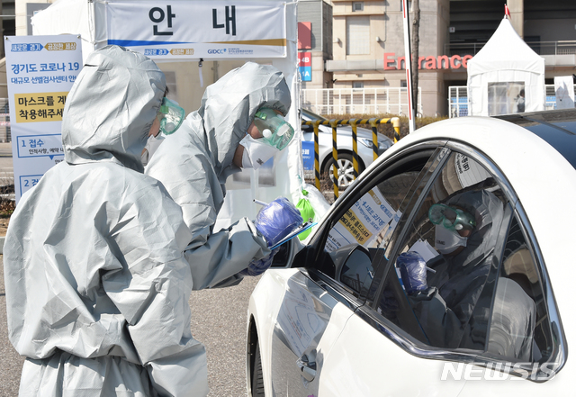 [수원=뉴시스] 김종택 기자 = 8일 오후 경기 수원시 팔달구 수원월드컵경기장에 설치된 신종 코로나바이러스 감염증(코로나19) 드라이브 스루 선별진료소에서 의료진이 검사를 하고 있다. 2020.03.08. semail3778@naver.com