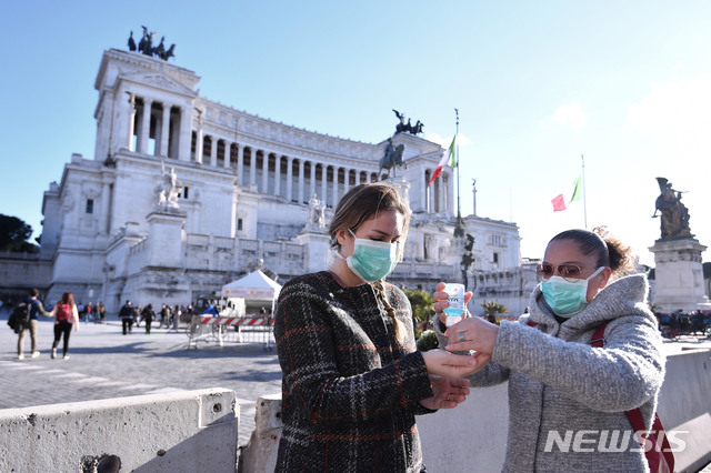 [로마=AP/뉴시스]지난 8일(현지시간) 이탈리아 로마 베네치아 광장에서 마스크를 쓴 여성들이 손을 소독하고 있다. 2020.03.09.