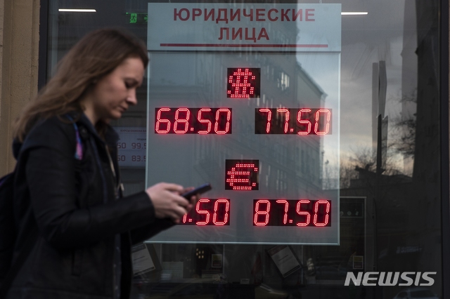 [모스크바=AP/뉴시스]9일(현지시간) 러시아 모스크바에서 한 여성이 환전소 앞을 지나고 있다. 2020.03.10. 