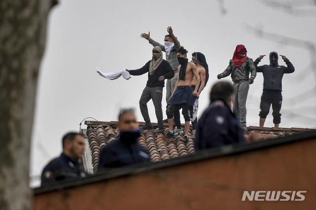 [밀라노=AP/뉴시스] 코로나 19로 전국에 이동금지령이 내려지자 지난 3월9일(현지시간) 이탈리아 밀라노 산비토레 교도소 수감자들이 면회 재개를 요구하며 폭동을 일으켜 지붕 위에 올라가 시위를 벌이고 있다. 2020.03.10 
