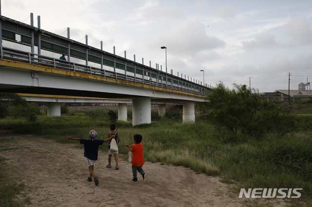 [AP/뉴시스] 2019년 6월 26일 미국과 멕시코 국경의 리오 그란데 부근의 강가를 걸어가는 이민 어린이들 . (미 국경수비대 사진) 