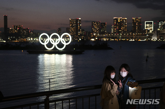 [도쿄=AP/뉴시스]일본 여성들이 지난 12일 2020 도쿄올림픽 오륜기 장식물을 배경으로 사진을 찍고 있다. 2020.03.16