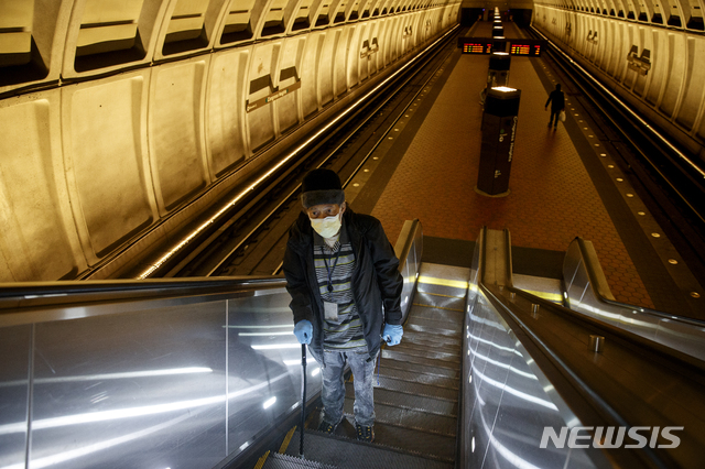 [워싱턴=AP/뉴시스]한 이용객이 지난 3월13일(현지시간) 미국 워싱턴DC 지하철에서 에스컬레이터를 타고 올라가고 있다. 2020.12.01.