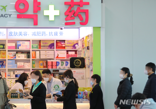 [제주=뉴시스]우장호 기자 = 마스크 5부제 둘째주인 16일 제주국제공항 내 약국에서 공항 이용객들이 공적마스크를 구매하기 위해 줄을 서 기다리고 있다. 2020.03.16.  woo1223@newsis.com 