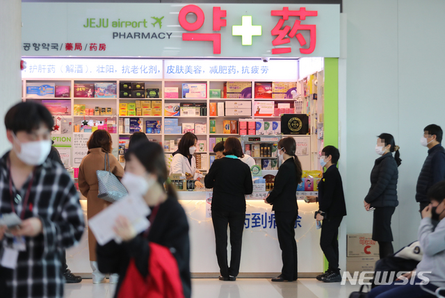 [제주=뉴시스]우장호 기자 = 마스크 5부제 시행 둘째주인 16일 제주국제공항 내 약국에서 공항 이용객들이 공적마스크를 구매하기 위해 질서 정연하게 줄을 서 기다리고 있다. 2020.03.16. woo1223@newsis.com