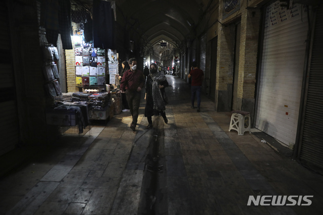 In this Tuesday, March 17, 2020, photo, people walk through the mostly closed Tehran&#039;s Grand Bazaar, Iran. The new coronavirus ravaging Iran is cutting into celebrations marking the Persian New Year, known as Nowruz. (AP Photo/Vahid Salemi)