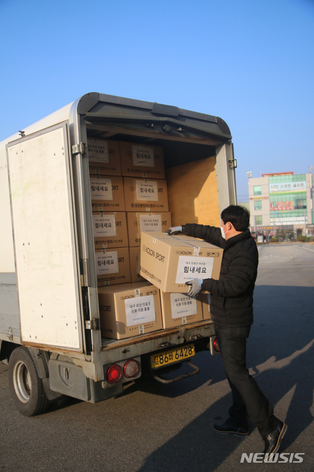 [서울=뉴시스] 대구 파견 공중보건의에게 지원할 의류물품을 옮기고 있는 모습. (사진=코오롱FnC 제공)