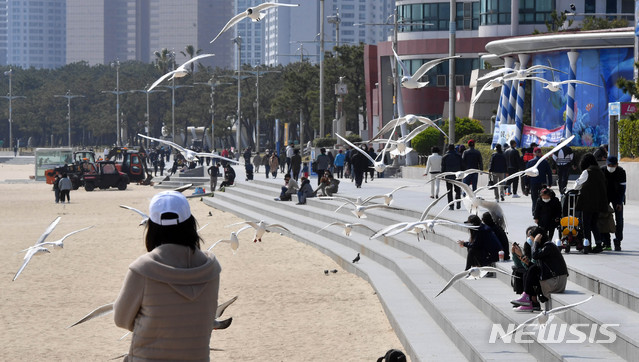 [부산=뉴시스] 하경민 기자 = 신종 코로나바이러스 감염증(코로나19)이 확산 중인 22일 부산 해운대구 해운대해수욕장을 찾은 시민과 관광객들이 봄나들이를 즐기고 있다. 2020.03.22. yulnetphoto@newsis.com