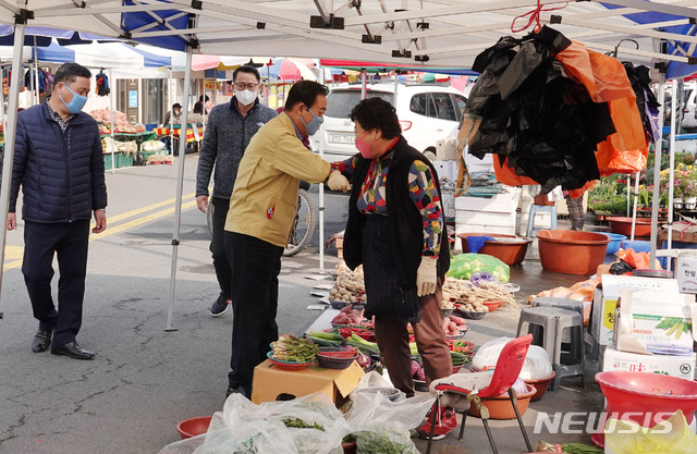 [창녕=뉴시스] 안지율 기자 = 한정우 경남 창녕군수는 22일 전통시장 5일장인 남지읍 남지시장을 찾아 신종 코로나바이러스 감염증(코로나19)으로 어려움을 겪는 시장상인과 팔꿈치 인사를 하고 있다.(사진=창녕군 제공) 2020.03.23. photo@newsis.com