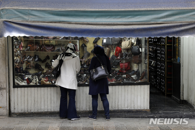 [테헤란=AP/뉴시스] 22일 이란 수도 도심이 코로나 19로 대부분 텅 빈 가운데 두 여성이 구두 가게를 들여댜보고 있다. 2020. 3. 23.