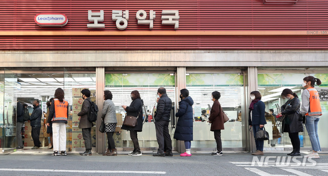 [서울=뉴시스] 고범준 기자 = 공적 마스크 5부제가 시행 중인 23일 오전 서울 종로구 종로5가에 위치한 한 약국에서 시민들이 마스크를 구입하기 위해 줄 지어 서 있다. 2020.03.23. bjko@newsis.com