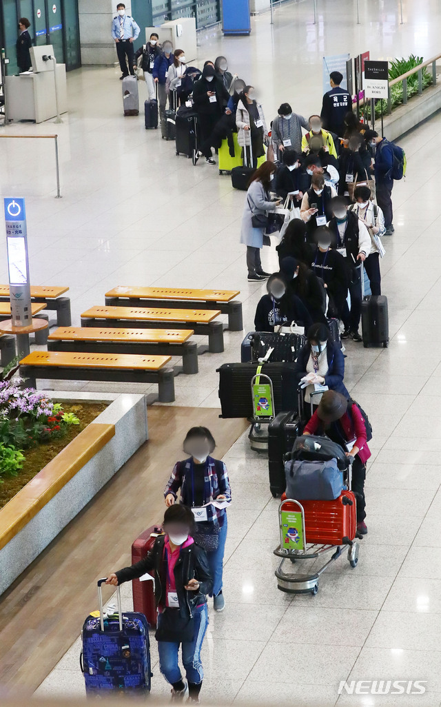 [인천공항=뉴시스]홍효식 기자 = 정부가 코로나19 관련 유럽발 입국자에 대한 검역을 강화한 가운데 23일 인천국제공항 1터미널에서 독일 프랑크푸르트 발 여객기를 타고 입국한 승객들이 격리시설로 이동하는 버스를 탑승하기 위해 줄지어 이동하고 있다. 2020.03.23.  yesphoto@newsis.com