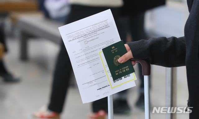 [인천공항=뉴시스]전신 기자 = 24일 인천국제공항 제2여객터미널에서 유럽발 내국인 입국자가 격리통지서를 들고 있다. 정부는 유럽발 신종 코로나 바이러스 감염증(코로나19) 유증상자 증가에 대비해 무증상 내국인은 당초 시설격리에서 자가격리로 전환하기로 했다. 2020.03.24. photo1006@newsis.com