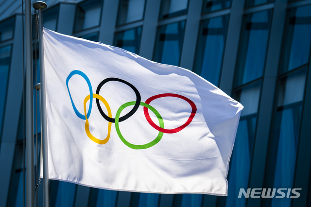 The Olympic flag is pictured at the entrance of the IOC, International Olympic Committee headquarters during the coronavirus disease (COVID-19) outbreak in Lausanne, Switzerland, Tuesday, March 24, 2020. (Jean-Christophe Bott/Keystone via AP)
