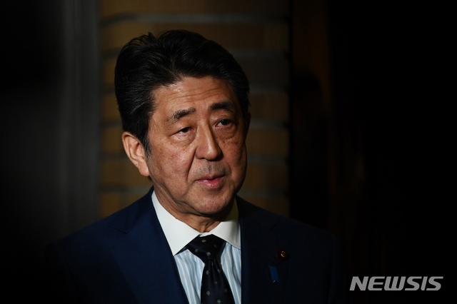 Japan&#039;s Prime Minister Shinzo Abe talks to journalists in front of the prime minister&#039;s residence in Tokyo, Tuesday, March 24, 2020. Abe says IOC president has agreed &quot;100%&quot; to proposal of postponing Olympics for about 1 year. (Charly Triballeau/Pool Photo via AP)