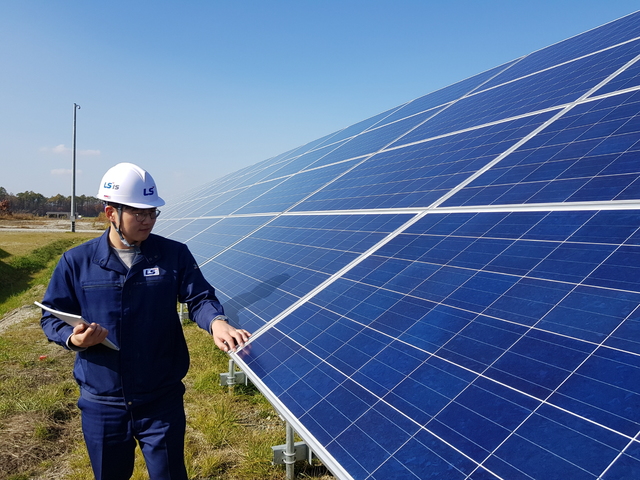 [서울=뉴시스] LS일렉트릭 관계자가 28MW급 일본 치토세 태양광 발전소 모듈을 점검하는 모습. 사진 LS일렉트릭