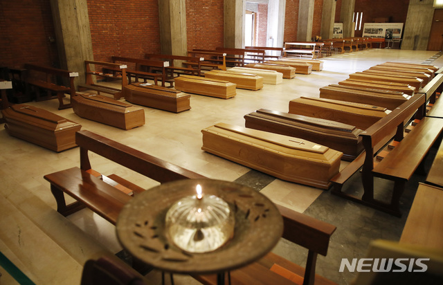 [베르가모=AP/뉴시스]지난 26일 이탈리아 베르가모 인근 한 교회에 화장 순서에 따라 관이 늘어서 있다. 존스홉킨스대 확산 지도에 따르면 28일(현지시간) 기준 전 세계에선 64만589명의 신종 코로나바이러스 감염증(코로나19) 누적 확진자와 2만9848명의 사망자가 나왔다. 이탈리아에서만 1만명 이상이 사망했다. 2020.03.29.