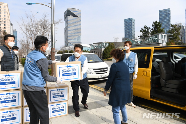 [서울=뉴시스] 포스코건설은 드라이브 스루 방식으로 코로나 예방 키트를 공동생활가정에 전달했다. 한성희 사장(가운데)이 키트를 옮기고 있다. (제공 = 포스크건설)