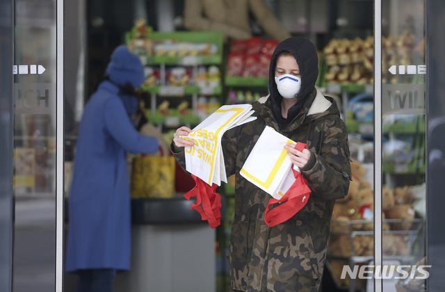 [비엔나=AP/뉴시스] 30일 오스트리아 수도에서 마스크 착용 여성이 슈퍼마켓을 나오고 있다. 이 나라는 1일부터 슈퍼에서 마스크 착용을 의무화한다  2020. 3. 30. 