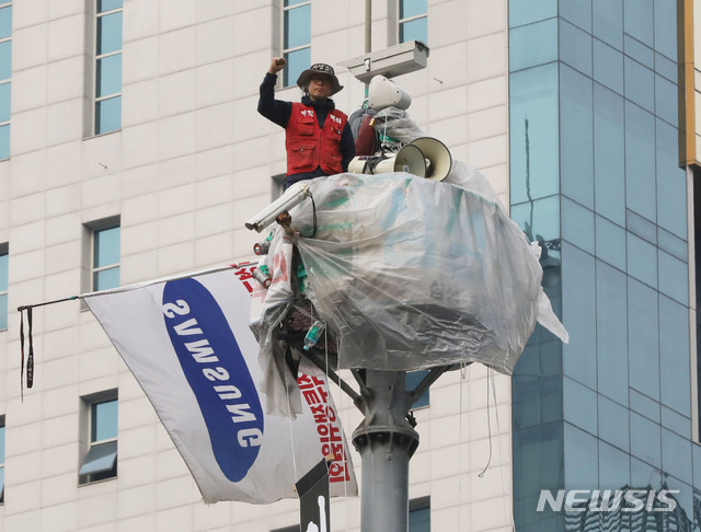 [서울=뉴시스] 고범준 기자 = 삼성 해고노동자 김용희 씨가 지난달 31일 오후 고공농성중인 서울 강남역 사거리 인근 철탑에서 심상정 정의당 대표를 만나기 앞서 투쟁을 외치고 있다. 2020.03.31.bjko@newsis.com