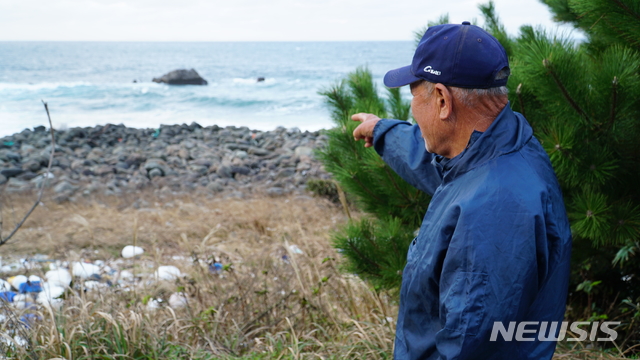 [제주=뉴시스]우찌하마 수구레(78)씨가 일본 대마도 북서쪽에 위치한 사고만에서 70여 년 전 한국인 시신을 화장한 '히토야케바(사람 태우는 곳)'를 가리키고 있다. (사진=제주CBS 제공)