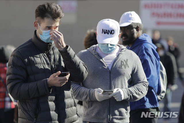 [뉴욕= AP/뉴시스] 미국 뉴욕주 뉴욕 퀸스의 식료품 체인 트레이더 조 앞에서 사람들이 마스크를 낀 채 줄을 서 있다. 2020.04.02. 
