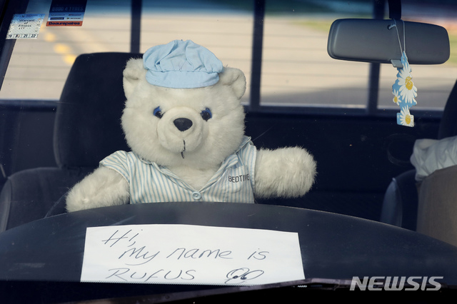 [크라이스트처치=AP/뉴시스] 지난달 31일(현지시간) 뉴질랜드 남섬 크라이스트처치 지역의 한 차량에 하늘색 모자를 쓴 곰 인형이 앉아있다. 앞에는 '안녕, 내 이름은 루퍼스야'라는 메시지도 적혀있다. 2020.4.2.