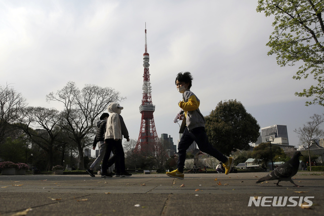 [도쿄=AP/뉴시스]신종 코로나바이러스 감염증(코로나19)확산 중인 일본 도쿄에서 3일(현지시간) 마스크를 낀 사람들이 걷고 있다. 2020.04.04.