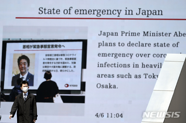 [도쿄=AP/뉴시스]6일 일본 도쿄에서 한 남성이 아베 신조 일본 총리가 신종 코로나바이러스 감염증(코로나19)에 대한 긴급사태를 선포할 계획이라고 보도하는 화면 앞을 지나가고 있다. 아베 총리는 코로나19 관련 7일 도쿄도 등 7개 도도부현에 1개월 동안 '긴급 사태'를 선포할 것이라고 밝혔다. 2020.04.06.