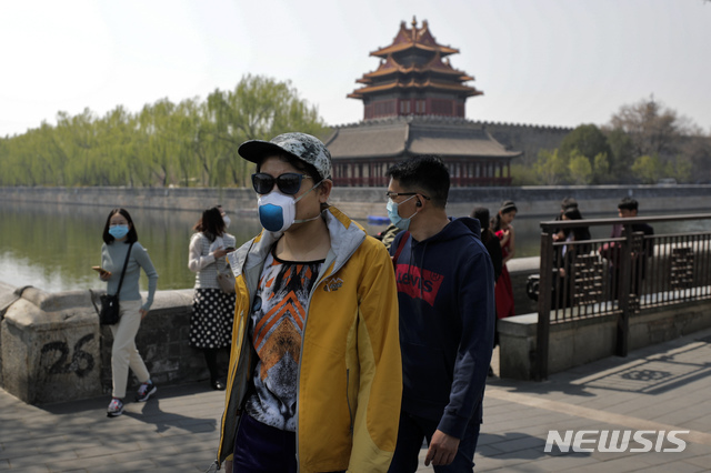 [베이징=AP/뉴시스] 중국 베이징 자금성 앞에서 6일 마스크를 쓴 관광객들이 걸어가고 있다. 자금성은 코로나19로 인해 아직도 폐쇄돼있다.2020.04.07