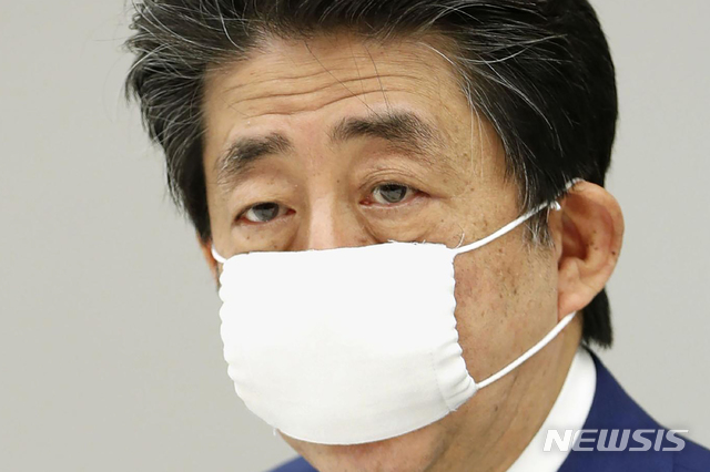 [도쿄=AP/뉴시스]지난해 4월 11일 당시 일본 총리였던 아베 신조(가운데)가 총리 관저에서 마스크를 쓴 채 코로나19 정부 대책 본부 회의를 주재하고 있다. 2020.04.13.