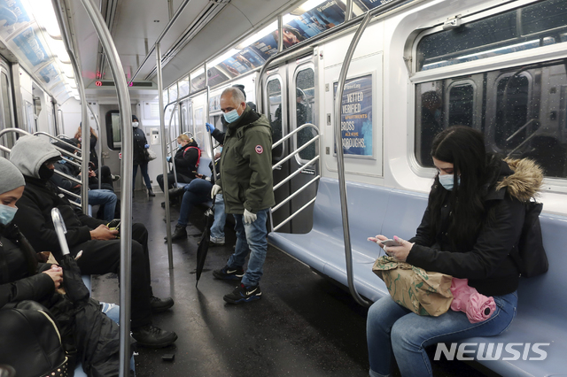 [뉴욕=AP/뉴시스] 13일(현지시간) 미국에서 신종 코로나바이러스 감염증(코로나19) 상황이 가장 심각한 뉴욕의 지하철에 승객들이 마스크를 낀 채 탑승한 모습. 2020.04.15.