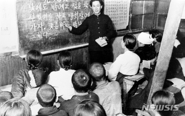 [서울=뉴시스] 1946년 겨울 ‘성인학교’에서 대학생으로부터 한글을 배우고 있는 주민들. 북한은 만 12세 이상 50세 미만의 남녀 문맹자들은 의무적으로 ‘성인학교’에 입학 시켜 매일 2시간 이상 교육을 받도록 한 후 수료자에게 수료 증서를 발급했다. (사진=미디어한국학 제공) 2020.04.19. photo@newsis.com