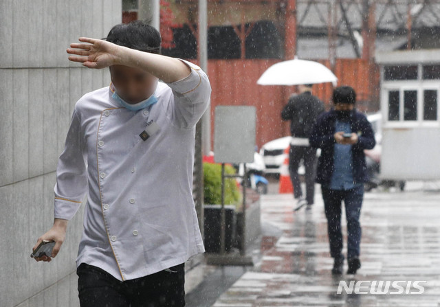 [서울=뉴시스] 박민석 기자 = 지난 4월19일 오후 서울 영등포구 일대에서 우산을 챙기지 못한 시민이 비를 피하고 있다. 2020.04.19. mspark@newsis.com