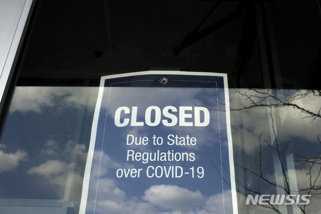 In this Wednesday, April 22, 2020 photo a closed sign is posted in the window of a store because of the coronavirus, in an outdoor mall, in Dedham, Mass. More than 4.4 million laid-off workers applied for U.S. unemployment benefits last week as job cuts escalated across an economy that remains all but shut down, the government said Thursday.  (AP Photo/Steven Senne)