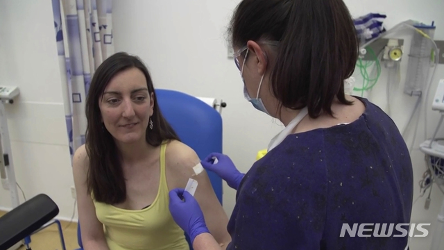 [옥스퍼드=AP/뉴시스]23일(현지시간) 영국 옥스퍼드의 옥스퍼드 대학교에서 미생물학자 엘리사 그라나토(왼쪽)가 신종 코로나바이러스 감염증(코로나19) 시험용 백신을 맞고 있다. 옥스퍼드대학 연구진은 이날 코로나19 백신 임상시험 자원자 800여 명 중 2명에게 처음으로 투약했다. 2020.04.24.