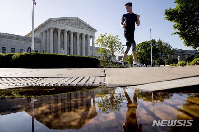 [워싱턴=AP/뉴시스]4일(현지시간) 미국 워싱턴에 위치한 연방대법원 앞에서 한 남자가 뛰고 있다. 2020.05.05.
