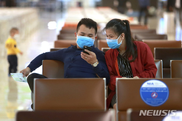 [하노이=AP/뉴시스]7일(현지시간) 베트남 하노이 공항 출국장에 신종 코로나바이러스 감염증(코로나19) 예방을 위해 마스크를 쓴 남녀가 휴대전화를 들여다보고 있다. 베트남은 지난 3주간 신종 코로나바이러스 감염증(코로나19) 확진 사례가 보고되지 않으면서 학교, 기업, 공장, 관광지 등을 다시 열었으나 이날 17명의 해외 유입 자국민 코로나19 환자가 생겨 비상이 걸렸다. 2020.05.08. 