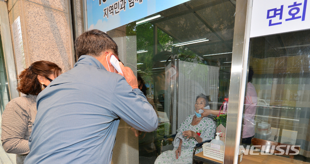 [광주=뉴시스] 변재훈 기자 = 어버이날인 지난 5월8일 광주 광산구 우산동 한 요양병원에서 입원환자와 가족들이 비접촉 면회를 하고 있다. 병원 측은 코로나19 확산 방지를 위해 건물 외벽 유리창을 사이에 두고 무선 전화로 대화할 수 있는 비접촉 면회실을 마련했다. 2020.05.08. wisdom21@newsis.com