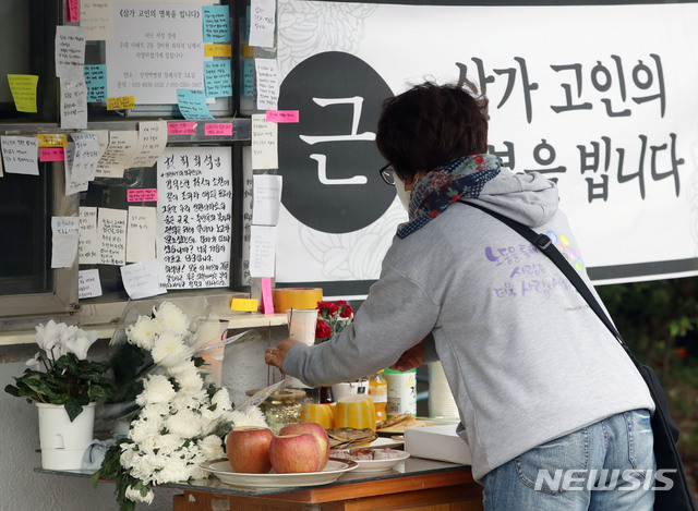 [서울=뉴시스] 박미소 기자 = 지난 5월12일 서울 강북구 우이동의 한 아파트 경비실 앞에 마련된 고(故) 최모 경비원를 위한 추모 공간에서 한 시민이 분향을 하고 있다. 2020.05.12. misocamera@newsis.com