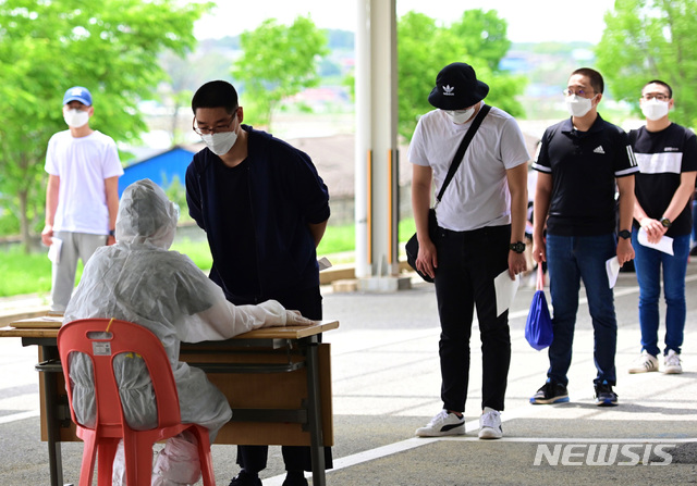 [서울=뉴시스] 18일 의료진이 육군훈련소로 입소한 입영장정을 대상으로 코로나19 예방을 위해 PCR검사 전수조사를 위한 검체 채취에 앞서 문진표를 작성 하고 있다. (사진=육군 제공) 2020.05.18.   photo@newsis.com