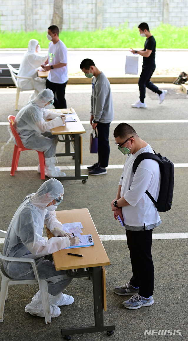 [서울=뉴시스] 18일 의료진이 육군훈련소로 입소한 입영장정을 대상으로 코로나19 예방을 위해 PCR검사 전수조사를 위한 검체 채취에 앞서 문진표를 작성 하고 있다. (사진=육군 제공) 2020.05.18.  photo@newsis.com
