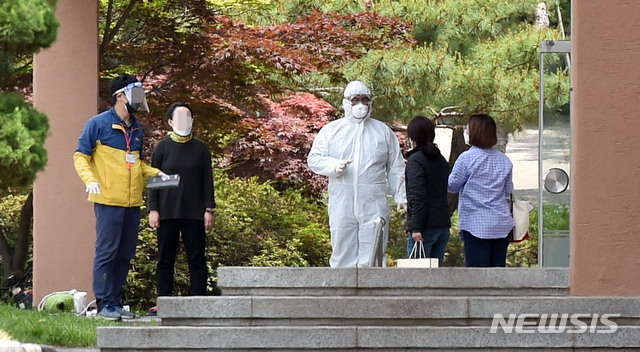 [대구=뉴시스] 이무열 기자 = 21일 고등학교 3학년 학생 1명이 신종 코로나바이러스 감염증(코로나19) 확진 판정을 받은 것으로 알려진 대구 수성구 노변동 대구농업마이스터고에서 방호복을 착용한 보건소 관계자와 학교 관계자들이 이야기를 나누고 있다. 2020.05.21.lmy@newsis.com